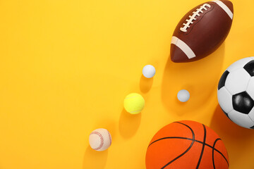 Many different sports balls on yellow background, flat lay. Space for text