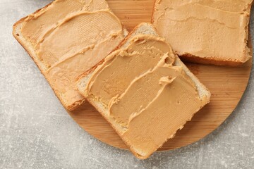 Tasty peanut butter sandwiches on gray table, top view