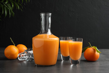 Delicious tangerine liqueur and fresh fruits on grey table