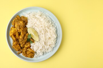 Delicious chicken curry with rice on yellow background, top view. Space for text
