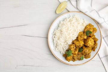 Delicious chicken curry with rice on white wooden table, top view. Space for text