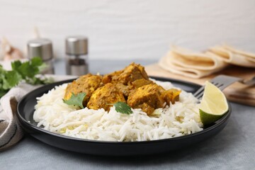 Delicious chicken curry with rice on grey table, closeup