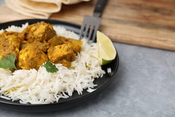 Delicious chicken curry with rice on grey table, closeup