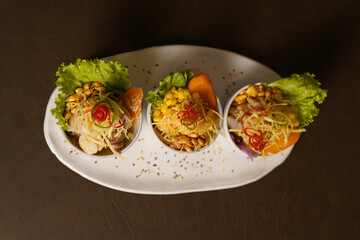 Plato de Triada de Ceviches en fondo oscuro