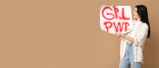 Young woman holding placard with slogan GRL PWR on beige background with space for text. Feminism...