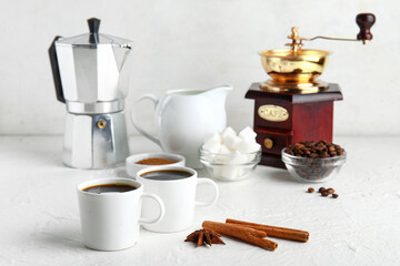 Cups of tasty coffee coffee with cinnamon on white background