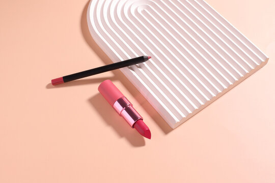 Lip pencil and lipstick on wavy podium, pink make up set