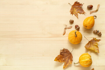 Autumn composition with pumpkins, acorns and leaves on wooden background
