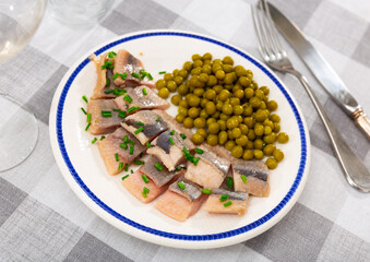 Appetizing herring, cut into pieces, with canned green peas
