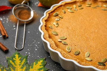 Baking dish with tasty pumpkin pie on black background