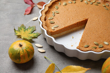 Obraz na płótnie Canvas Baking dish with tasty pumpkin pie on grey background