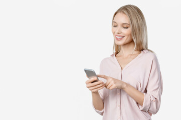 Cheerful girl holding mobile phone isolated over white background. Woman using cellphone for social media scrolling, cashback online shopping, remote job in application