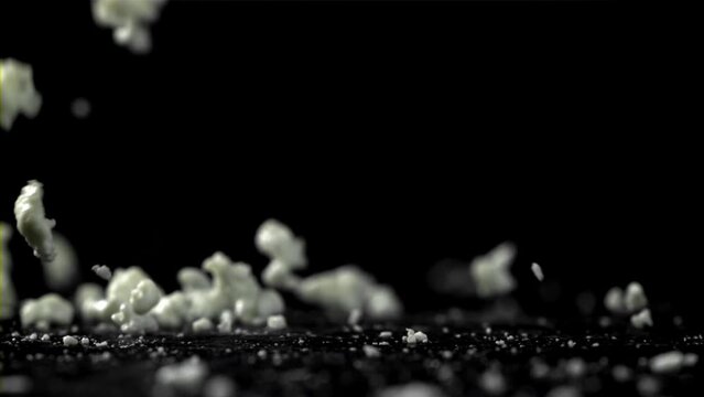 Fresh cottage cheese falling on black background. Filmed on a high-speed camera at 1000 fps. High quality FullHD footage