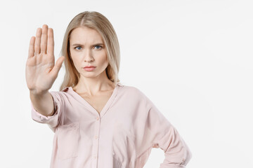 Angry woman gesturing stop sign over isolated white background. Prohibition not allowed...