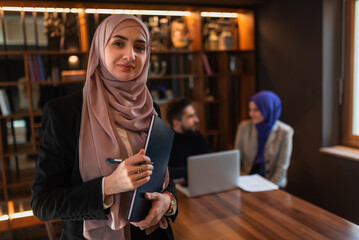 Portrait of a Muslim business woman front the working team in the office.