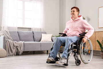 Smiling young man in wheelchair at home