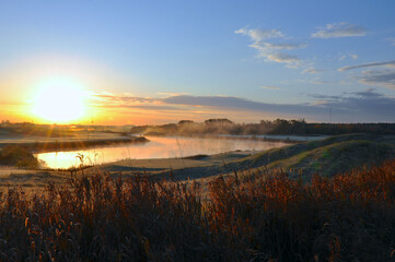Sunrise in the golf course with mist and birds