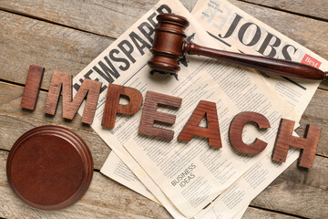 Word IMPEACH, judge gavel and newspapers on wooden background