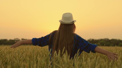 Young woman farmer arms to sides, runs through wheat field joy of good grain harvest. Beautiful...