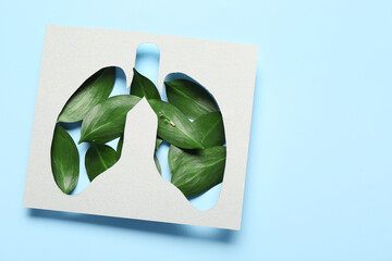 Paper cut out lungs and leaves on blue background