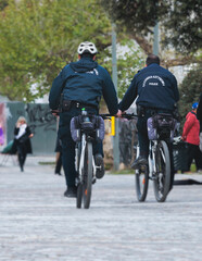 Hellenic Police on bikes with "Greek Police" logo on uniform, Greek police squad on duty riding bicycle, maintain public order in the streets of Athens, Attica, Greece, group of policemen on bycicles
