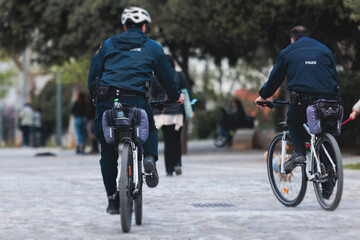 Fototapeta premium Police squad formation on duty riding bike and bicycle, maintain public order in the european city streets, group of policemen patrol on bycicles with 