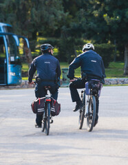 Fototapeta premium Police squad formation on duty riding bike and bicycle, maintain public order in the european city streets, group of policemen patrol on bycicles with 