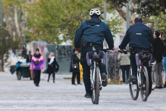 Police squad formation on duty riding bike and bicycle, maintain public order in the european city streets, group of policemen patrol on bycicles with "Police" logo emblem on uniform, Europe