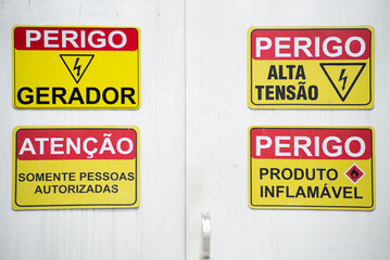 Sign indicating that there is high voltage energy and flammable product. Commercial District in the city of Salvador, Bahia.
