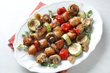 Delicious shish kebabs with vegetables and microgreens on white table, top view