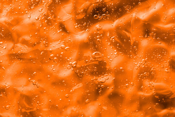 Texture of transparent cosmetic gel as background, closeup. Toned in orange