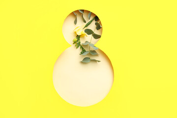 Cut paper in shape of figure 8 with beautiful flower on yellow background. International Women's Day