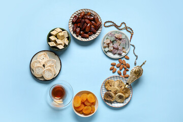 Frame made of traditional Eastern sweets, Aladdin lamp and tasbih for Ramadan on color background