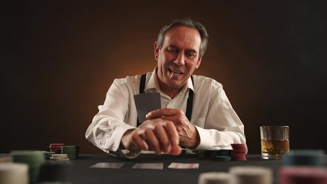 Confident man flipping cards on a table, revealing a winning poker hand. He is smoking a cigarette and assured of his victory. Brown background. Camera 8K RAW. 