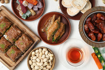 Composition with traditional Eastern sweets and tea for Ramadan on light background