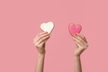 Woman with heart-shaped cookies on pink background. Valentine's Day celebration