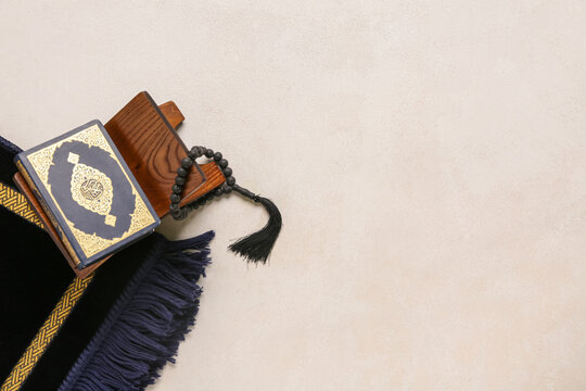 Rehal with Koran and prayer beads for Ramadan on white grunge background