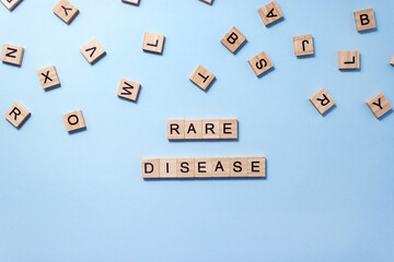 Words Rare Disease composed of wooden blocks with letters on blue background. Healthcare concept....