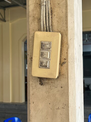 Fototapeta na wymiar A white light switch on an old wooden pole