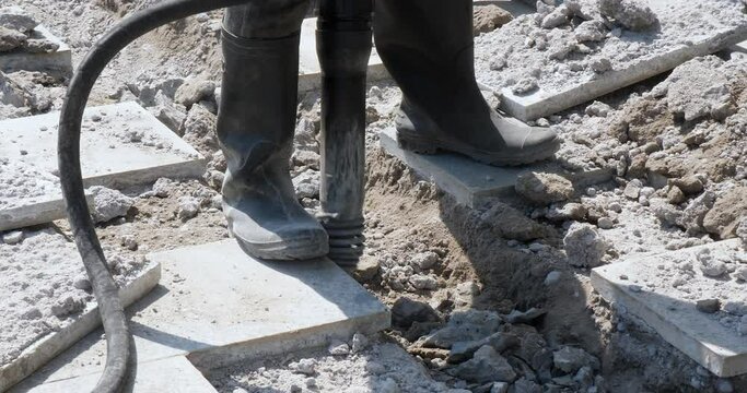 close up of a construction worker breaking up the street with a jackhammer