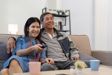 Asian senior couple enjoying in their favorite TV. Happy retirement couple watching television...