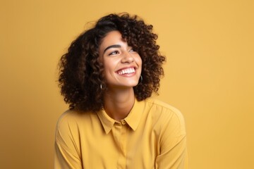 Obraz na płótnie Canvas Portrait of cheerful young african american woman in yellow shirt on yellow background