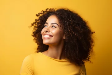 Fotobehang Portrait of happy african american woman with curly hair over yellow background © Iigo