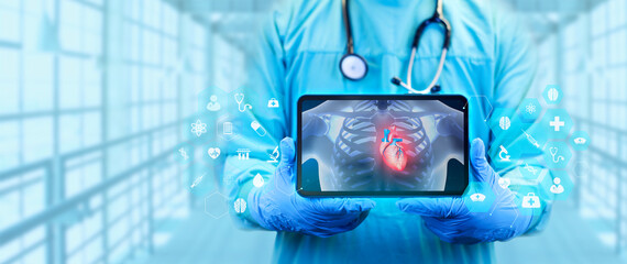 The doctor analyzes the heart angiogram, Doctor with tablet shows an x-ray isolated on a light blue...