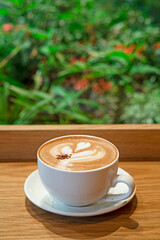 Mocha Caffé latte on wooden table and Coffee shop blur background with bokeh image.