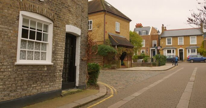 Shot of narrow street with houses made of Twickenham architecture in London, England on a cloudy day.