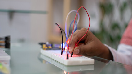 Child's hand making electrical connections to turn on led lights