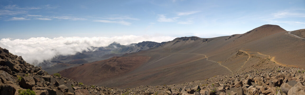 Standing on Top of Haleakala giant volcano crater, beautiful sunny day panoramic view with clouds below, Maui Hawaii 