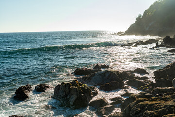 Beach during sunset with rocks on the coast