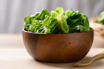 Organic cos romaine lettuce in wooden bowl, Food ingredient for healthy salad